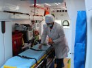 Лаборант бере для аналізу змиви з поверхонь в медичному автомобілі перед обробкою