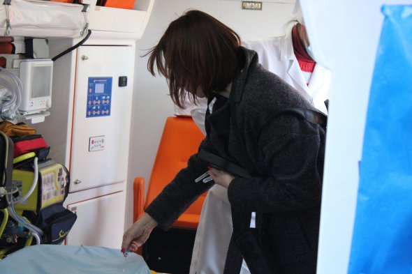 Співробітниця компанії дистриб'ютора бере на аналіз змиви з поверхонь в медичному автомобілі перед обробкою