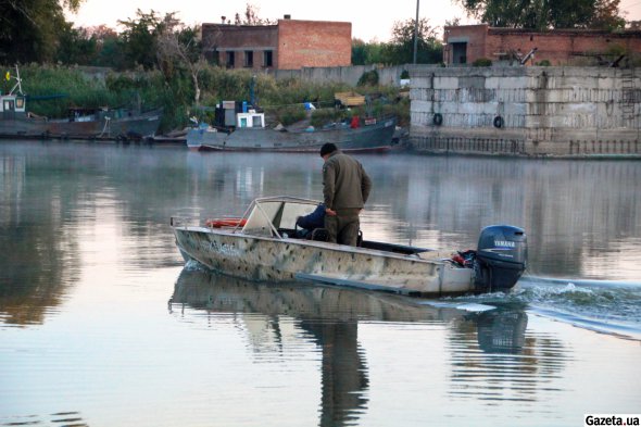 Рибалки-любителі на легкому моторному човні ранком вирушають на риболовлю