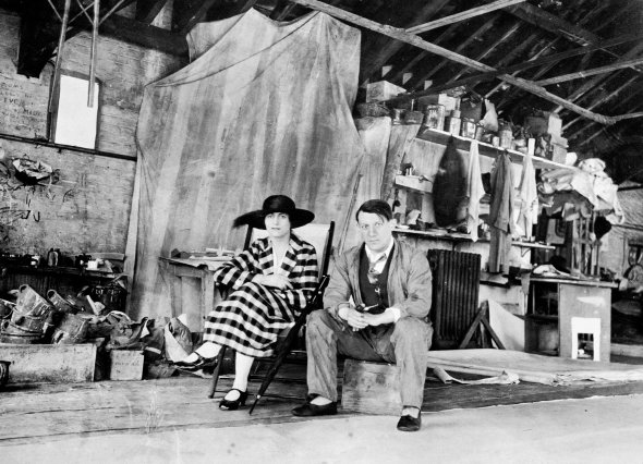 Художник Пабло Пікассо з дружиною Ольгою сидять у майстерні живопису в Лондоні, літо 1919 року. Митець приїхав в Англію, щоб працювати над декораціями й костюмами до балету ”Капелюх” Мануеля де Фальї. Його поставила трупа Сергія Дягілєва
