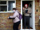 Мужчина в маске машет рукой, пока волонтеры раздают жителям домашние наборы для тестирования COVID-19, Великобритания, 2 февраля