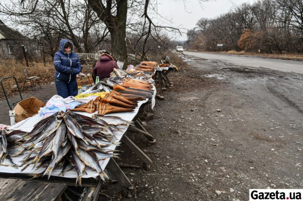 Жінки торгують рибою на обочині дороги в прифронтовій Карлівці