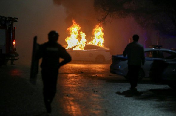Міліцейська машина горить під час акції протесту в Алмати, 5 січня