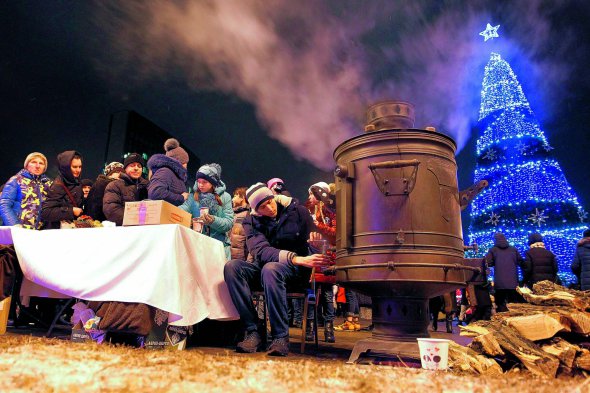 Люди зібралися біля самовара під час включення вогнів новорічної ялинки в контрольованому росіянами Донецьку, 21 грудня 2018 року