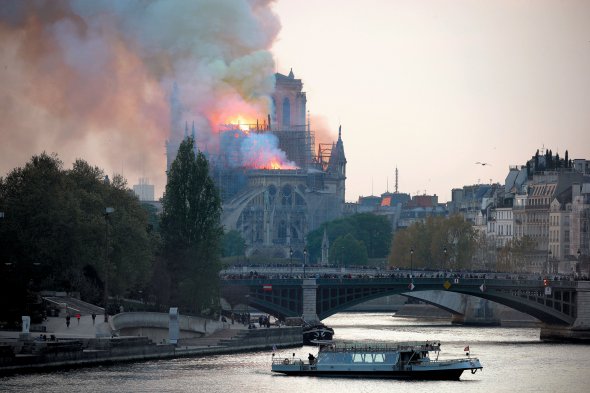 Люди з мосту через Сену дивляться, як горить собор Нотр-Дам у Парижі увечері 15 квітня 2019 року