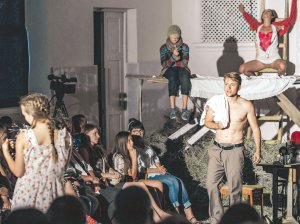 Юрій Радіонов (голий по пояс) у виставі ”Кайдаші 2.0” київського ”Дикого театру” грає молодшого сина Омелька Кайдаша — Лавріна, виходить від коханки Тетяни (ззаду на драбині) — актриса Анна Абрамьонок, і бачить майбутню дружину Мелашку — втілила Анна Сердюк
